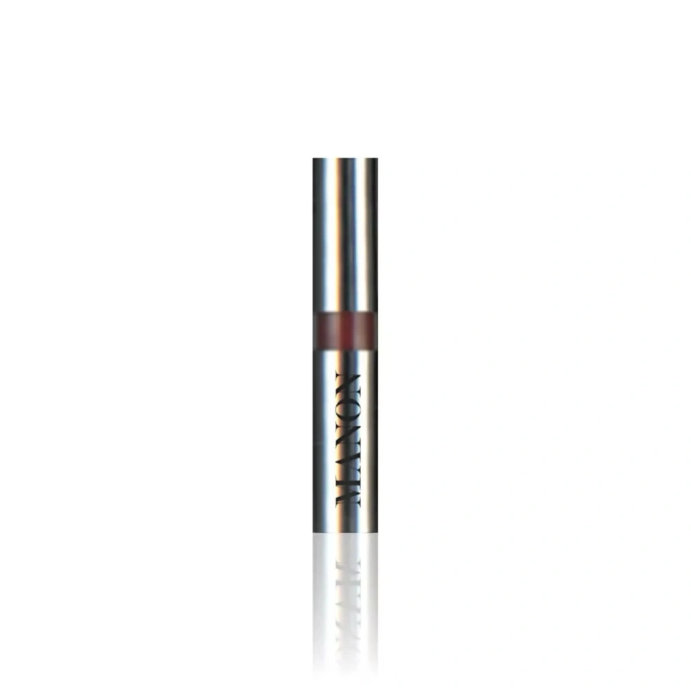 A silver metallic lipstick tube, branded "MANON," with a dark red band indicating the product color, stands vertically against a white background.